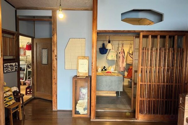 A traditional Japanese interior with sliding doors, a reception desk, and a display of merchandise. - Mojiko guesthouse PORTO (Kitakyushu)