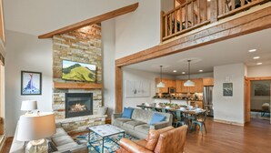 Una sala de estar amplia con chimenea, comedor y cocina.