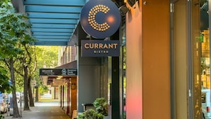 Straatbeeld van een gebouw met een bord voor Currant Bistro.