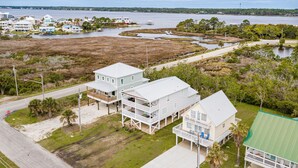 A coastal property with two main buildings, a dock, and a view of the water. - Beach Days & Fire Nights! Family 3BR Duplex Just Steps from the Sand! (Gulf Shores)