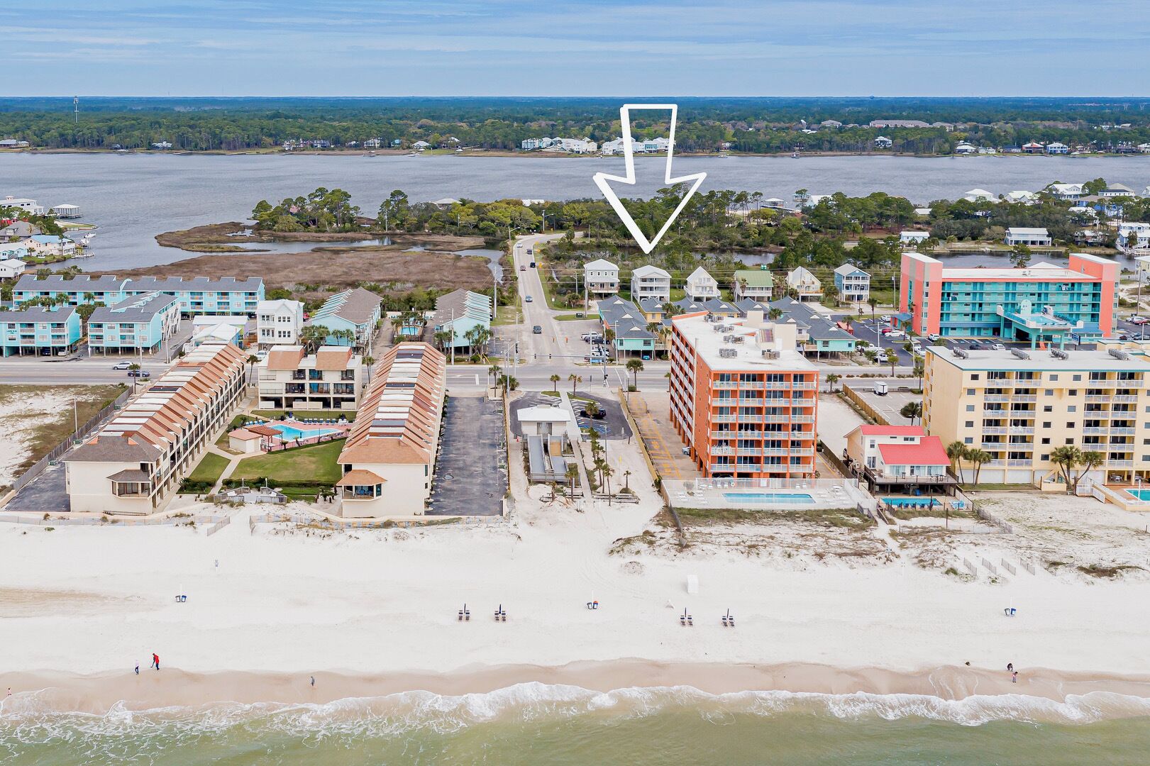 Un hôtel situé sur la côte, composé de plusieurs bâtiments, avec une plage et un plan d’eau.
