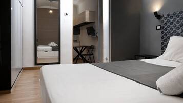 Un dormitorio moderno con cama, escritorio y armario.