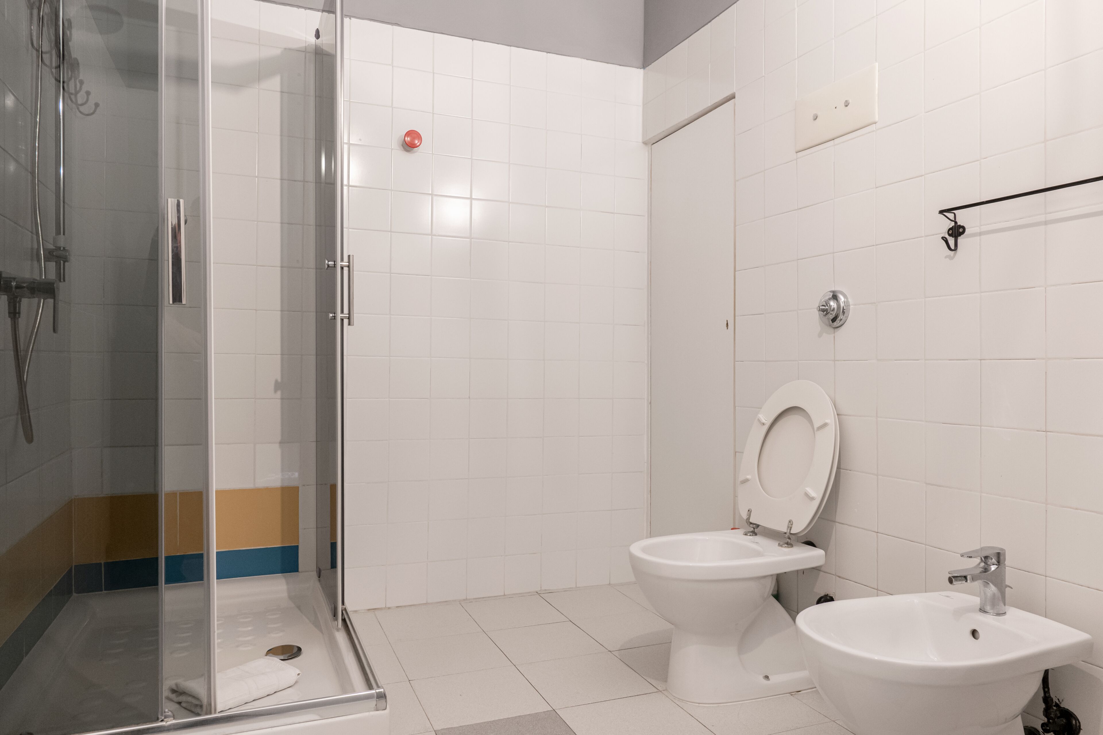 A bathroom with a glass-enclosed shower, a toilet, and a sink.
