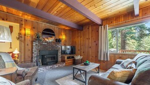 A cozy living room with a fireplace, comfortable seating, and a TV.