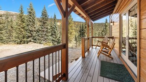 A wooden deck with a view of a forest and mountains. - Pet-Friendly Creek Cabin on 8 Acres - Billiards, Borders Natl Forest (Alma)