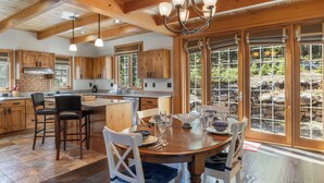 A spacious kitchen with wooden cabinets, a central island, and a dining area with a wooden table and chairs. - Pet-Friendly Creek Cabin on 8 Acres - Billiards, Borders Natl Forest (Alma)