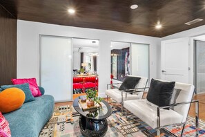Un salon moderne avec un canapé, des fauteuils et une table basse.