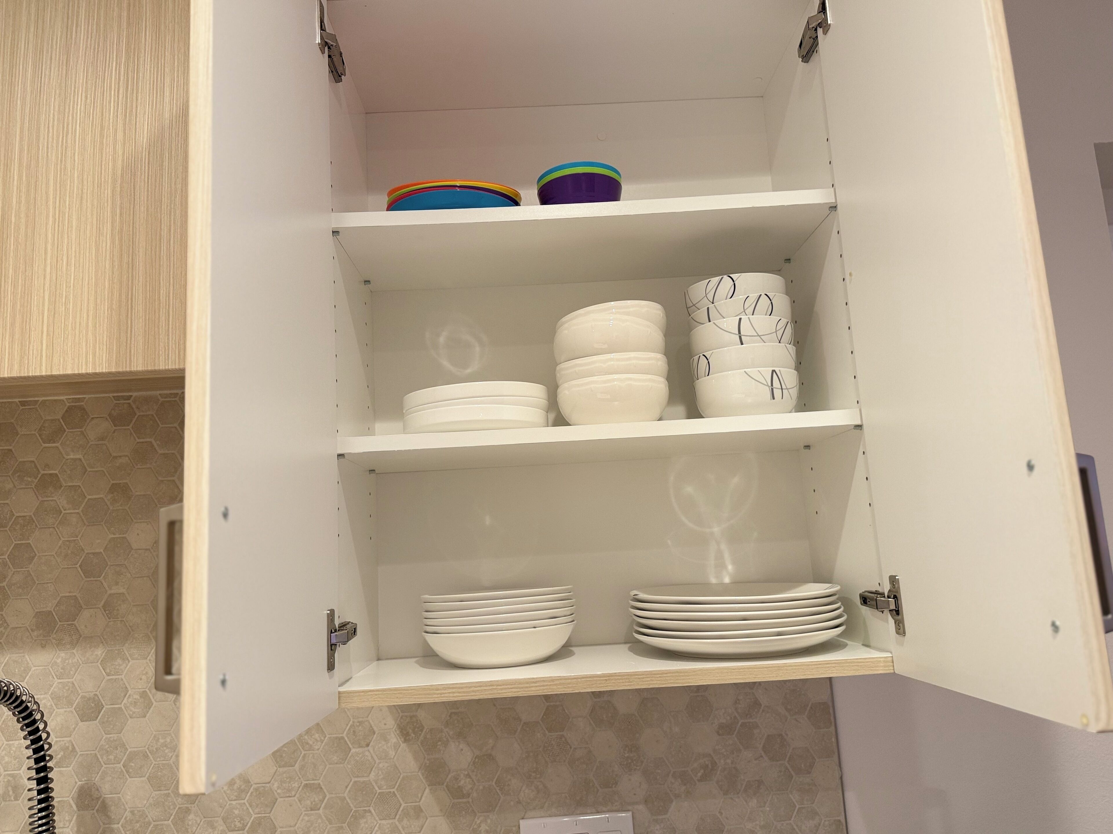 Un meuble de cuisine doté de plusieurs étagères contenant divers ustensiles et accessoires de cuisine.