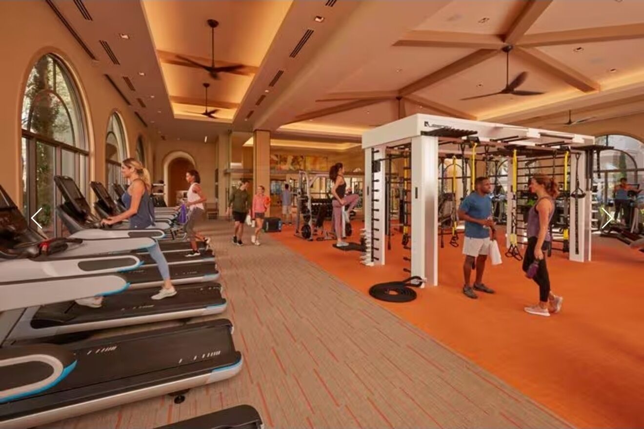 Un gimnasio con cintas de correr, máquinas de pesas y una zona de dominadas.