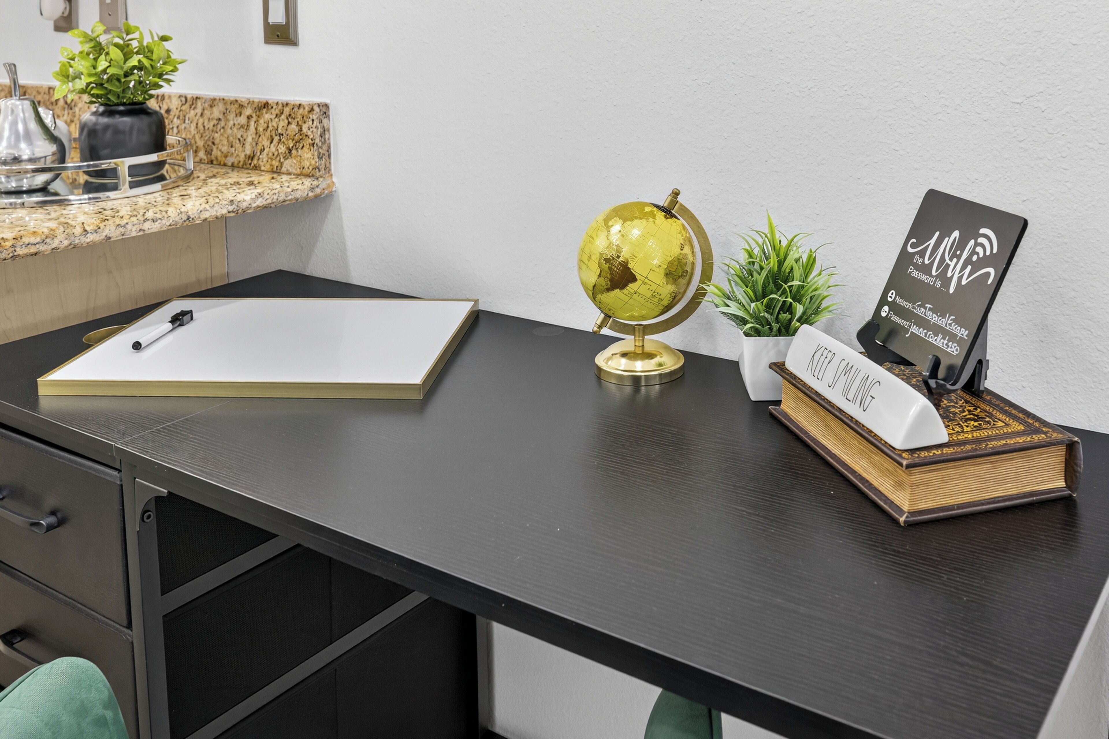 A desk with a globe, a book, a pen, and a small plant.
