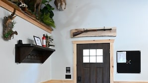 Un intérieur en bois avec un banc, une porte et un tableau d’affichage.