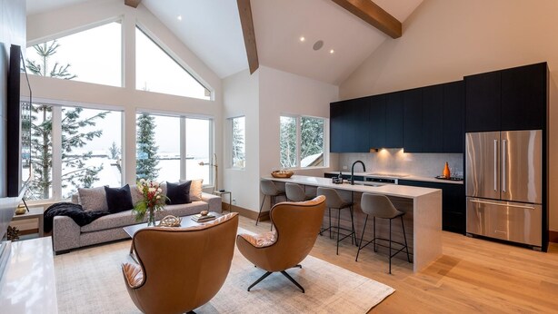 A modern kitchen with a central island, stainless steel appliances, and large windows offering views of trees. - Northern Lights 32 | Ski-in/out Luxury Townhome, Hot Tub, (Whistler)