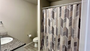 Ein Badezimmer mit Waschbecken, Toilette und Duschvorhang.