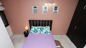 A bedroom with a bed, a nightstand, a lamp, and a wardrobe. - Yalie Home and Co (Rivieria 3 bonoumin)