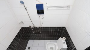 A bathroom with a white toilet, a shower with a control panel, and a grab bar. - Yalie Home and Co (Rivieria 3 bonoumin)