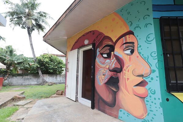 A building with a colorful mural, a door, and a concrete pathway.
