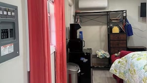Une chambre à coucher comprenant un lit, un bureau, une poubelle, un radiateur et une armoire.