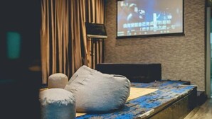 A cozy room with a bed, pillows, a TV screen, and a projector. - Tun Aminah Shoplot 10-14pax KTV Mahjong Funhouse (Sekudai)