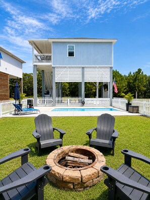 A two-story house with a pool, a fire pit, and outdoor seating. - Beautiful New Home Near Beach with Pool Sleeps 6 (Pass Christian)