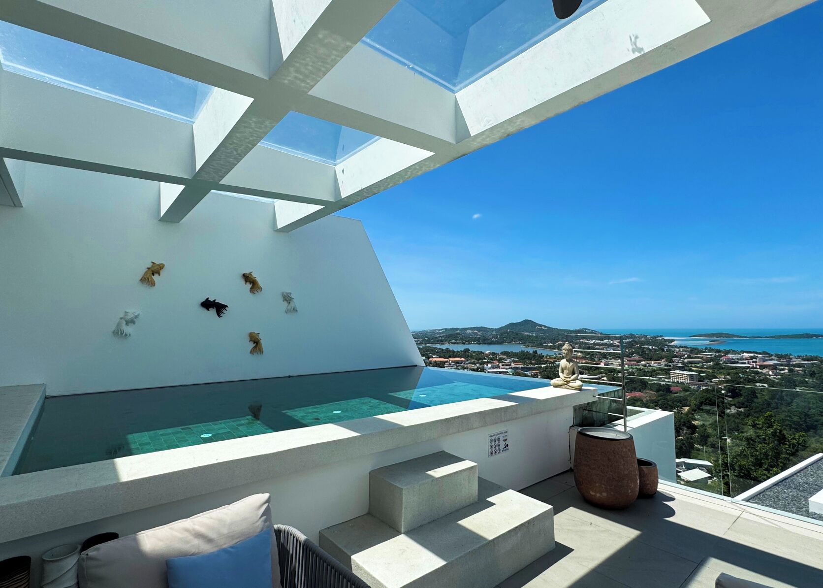 A modern infinity pool with a clear view of the sea and landscape.