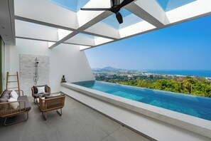 A modern balcony with a glass barrier, a ceiling fan, and a view of the ocean. - Golden Lotus Villas (Koh Samui)