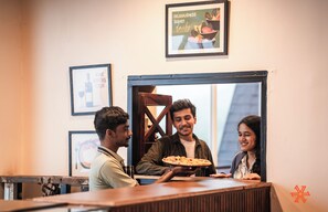 A restaurant counter with a pizza being served. - Zostel Kodaikanal (Vilpatti) (Kodaikanal)