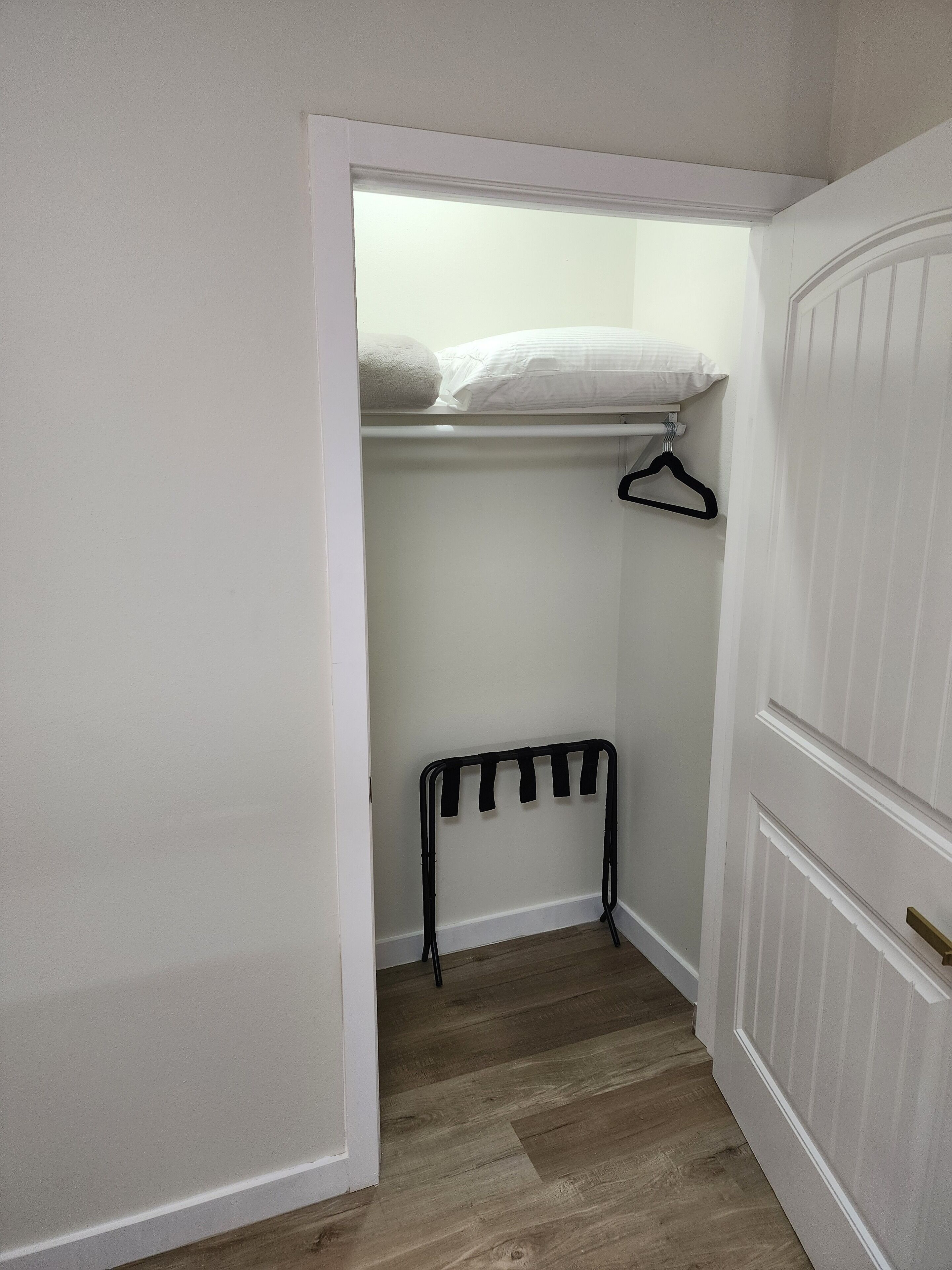 A walk-in closet with a hanging rack and a radiator.