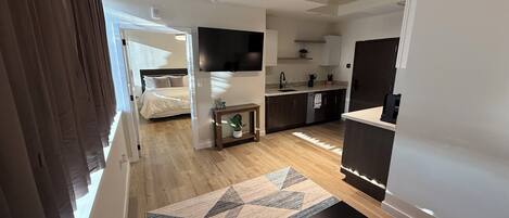 Ein modernes Apartment mit Schlafzimmer, Küchenzeile und Essbereich.