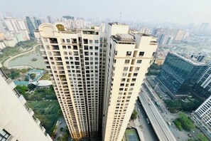 A high-rise building with multiple floors and a central core, surrounded by other high-rise buildings and a river. - Vinhomes D'Capitale - Luxury Kane Aparment In Ha Noi (Hanoi)