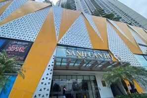 A building with a distinctive geometric facade, featuring a prominent entrance with a sign that reads 'SANI CANHO.' - Vinhomes D'Capitale - Luxury Kane Aparment In Ha Noi (Hanoi)