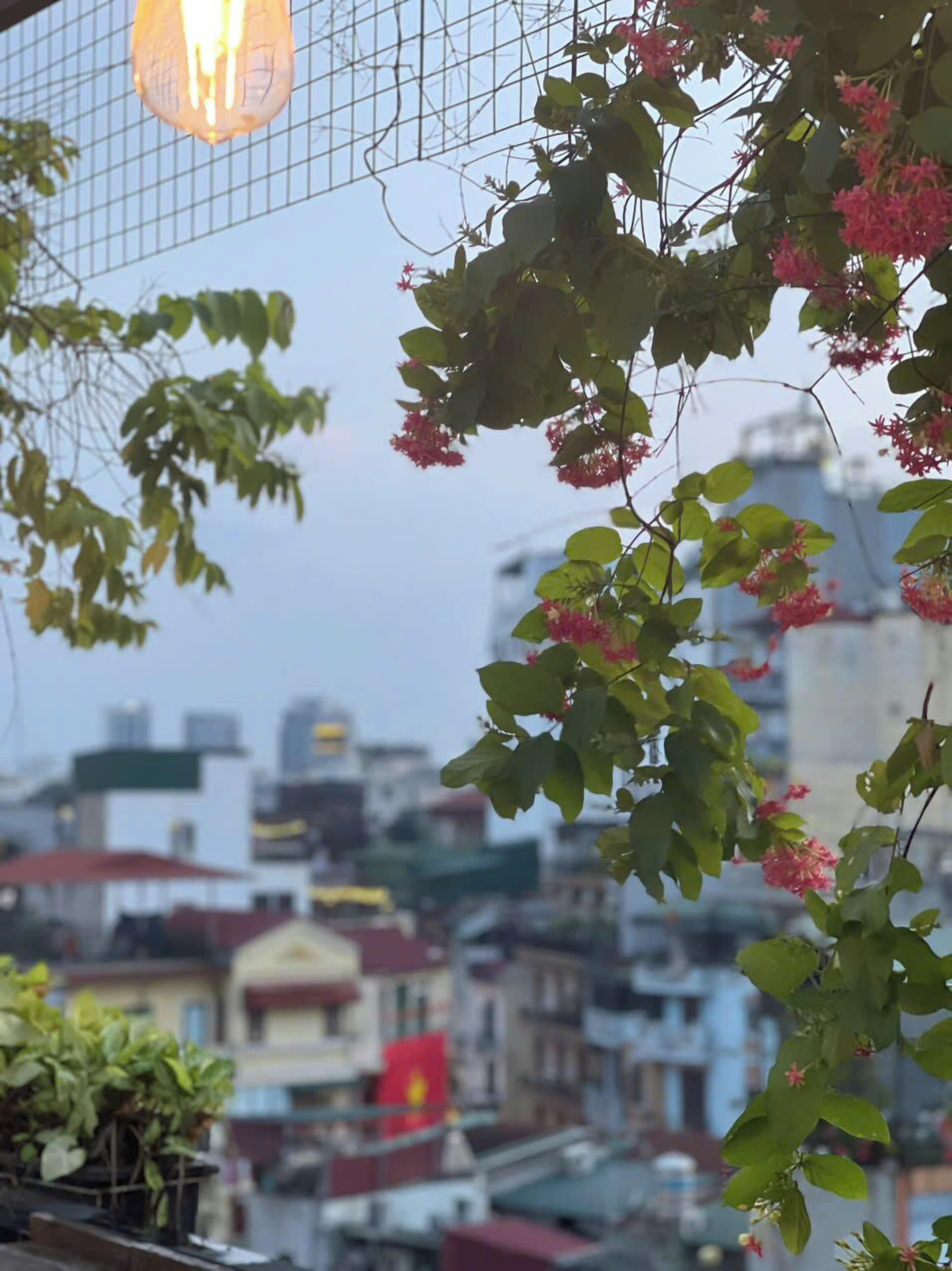 A cityscape with buildings, a red flag, and a hanging light fixture.