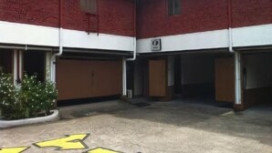 A building with a red and white facade, multiple doors, and a small garden area with a potted plant. - Halina Drive Inn Hotel - Pasay (Pasay)