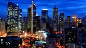A cityscape at night with illuminated skyscrapers and a busy street. - Halina Drive Inn Hotel - Pasay (Pasay)