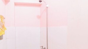 A bathroom with a shower, a towel rack, and a toilet.