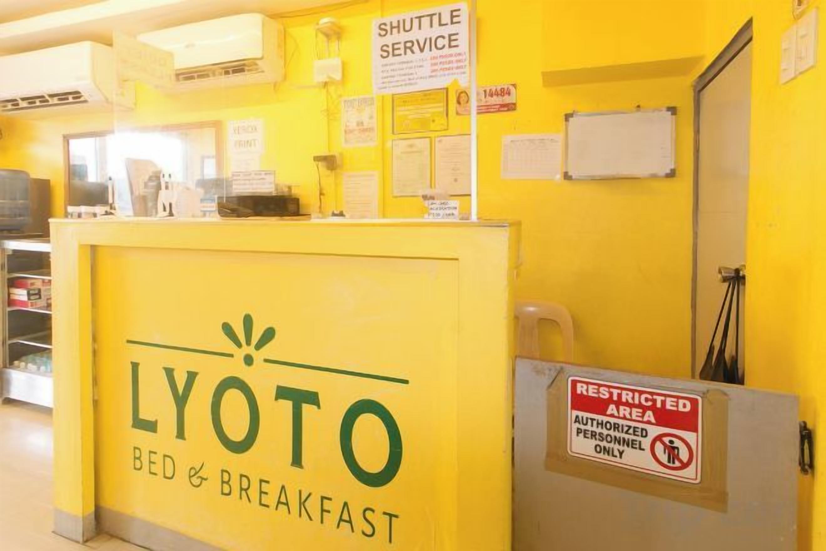 Un comptoir d’accueil avec un panneau indiquant la présence d’un service de navette et un avis indiquant qu’il s’agit d’une zone à accès restreint.