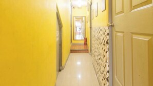 A narrow hallway with yellow walls and a tiled floor.
