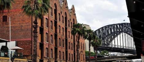 Un edificio storico con finestre ad arco e facciata in mattoni, situato vicino a un ponte.