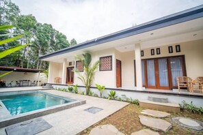 A modern house with a swimming pool, a covered patio, and a garden area. - Maha Gunung Guest House (Bali)