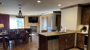 A modern kitchen with a built-in dishwasher, wooden cabinets, and a granite countertop.