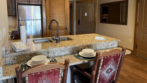 A kitchen with granite countertops, stainless steel appliances, and wooden cabinetry.