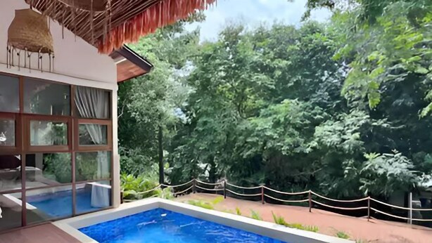 A swimming pool with a wooden deck, surrounded by a rope barrier and lush greenery. - Villa Bohème, Villa 28 (Koh Samui)
