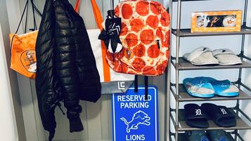 A storage area with various bags, a reserved parking sign, and shelves with shoes and slippers.