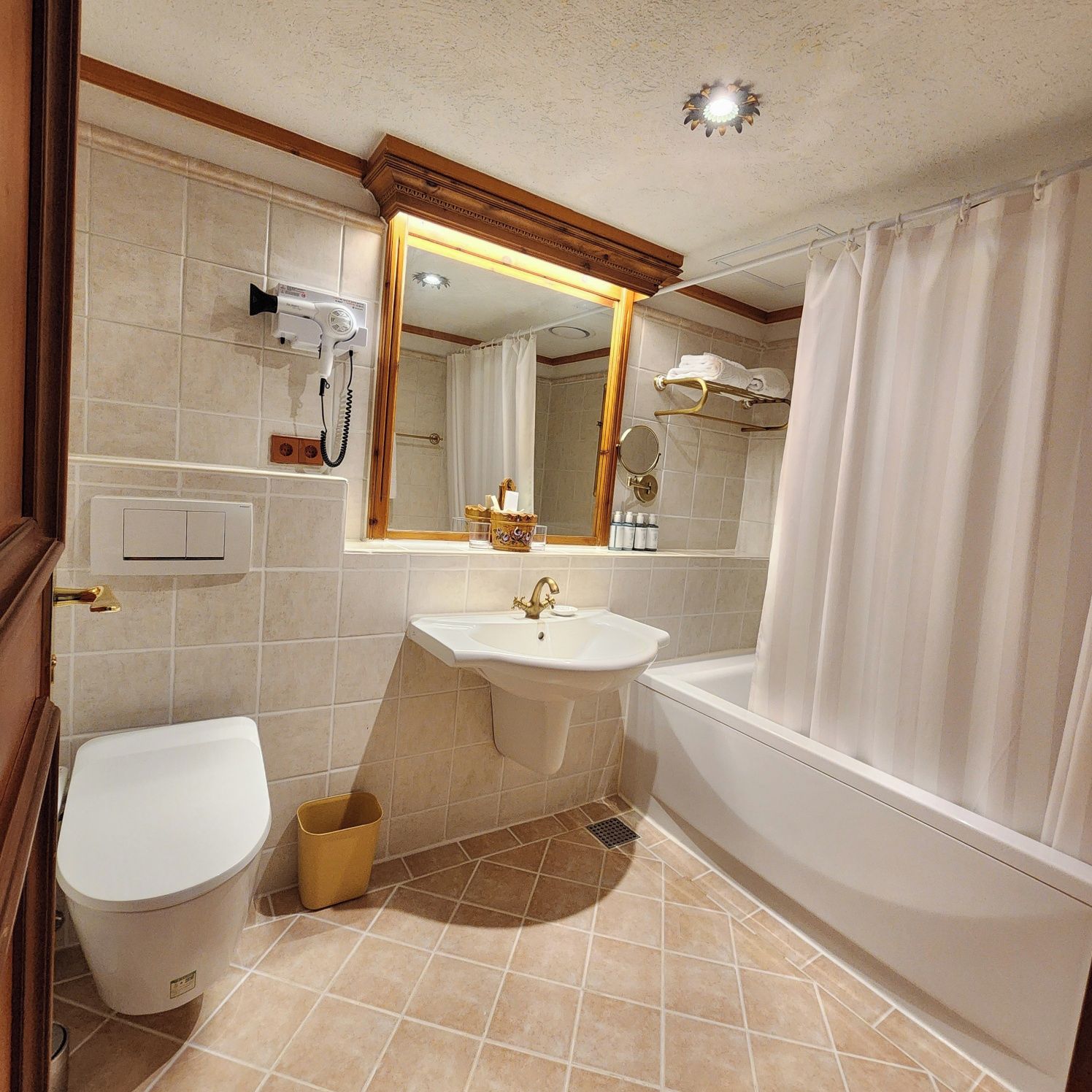 A bathroom with a toilet, sink, and bathtub.