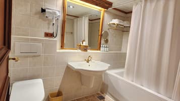 A bathroom with a toilet, sink, and bathtub.