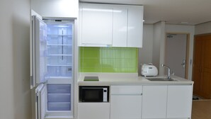 A compact kitchen with a built-in refrigerator, microwave, and sink. - Muju Deogyusan Resort (Muju)