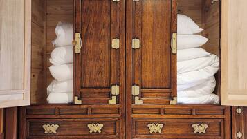 A wooden wardrobe with multiple drawers and a central door, featuring brass handles and hinges.
