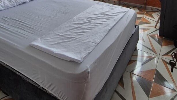A hotel room with a bed, a TV, a wardrobe, and a balcony with a view. - Hospedaje ASL HOME (Yumbo)
