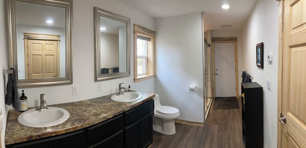 A bathroom with two sinks, a toilet, and a large mirror. - Ridgeline Retreat (Goldendale)