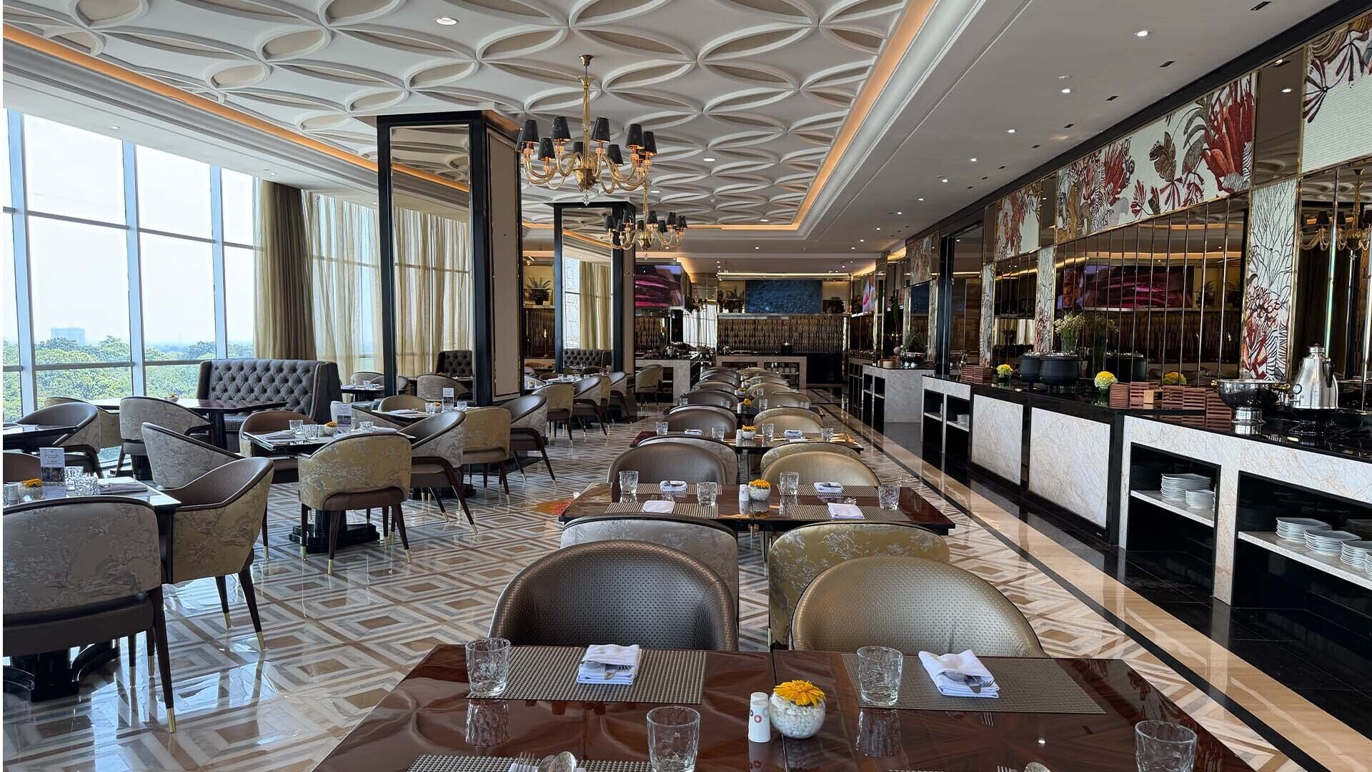 A restaurant with a long counter, multiple dining tables, and chairs.