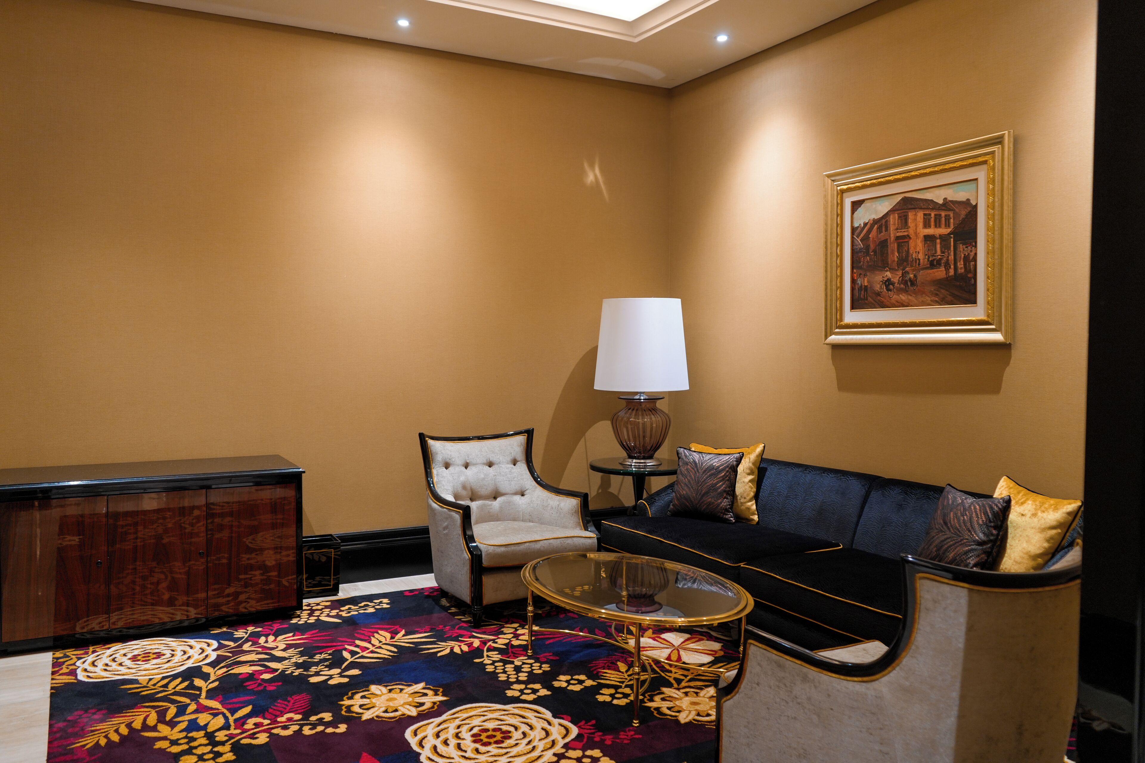 Una habitación con sofá, sillón, mesa de centro y una lámpara.